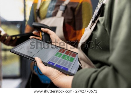 Close up of workers checking inventory with tablet and scanner, verifying airway bills on parcels and supporting e-business operations with shipment labels. Distribution logistics for orders.