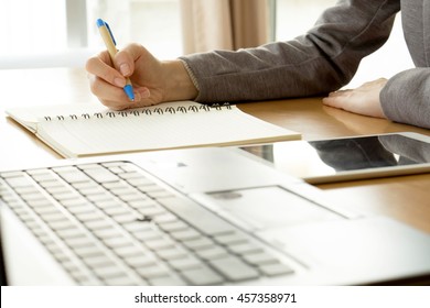 Close Up Working Woman Writing On Paper And Typing On Laptop Computer In Office Room