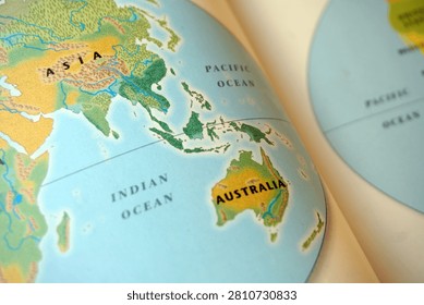 Close up of a world map illustration in a book focusing on Asia, Australia, and Indonesia. Education geography concept, vintage style atlas, travel and global discovery background.