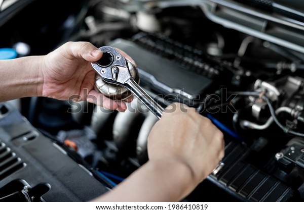 Close up wrench in hand a man with\
use change oil filter in engine room service concept of\
car
