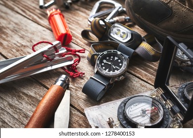 Close Up Of Wrist Watch, Compass, Knife And Other Camping Gear