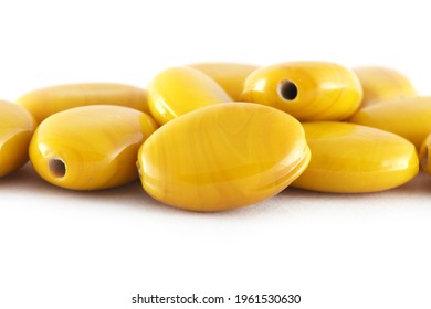 Close up of yellow Beads on the white background.Oval shape beads, Background or texture of beads. macro,used in finishing fashion clothes. make bead necklace or string of beads for woman of fashion.