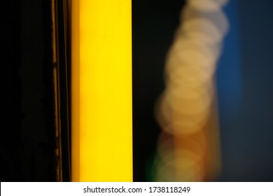 Close up yellow fluorescent lamp hanging beside street in the night, selective focused and blurred background. 