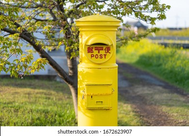 Close up of a yellow post, the letter 郵便 means post
