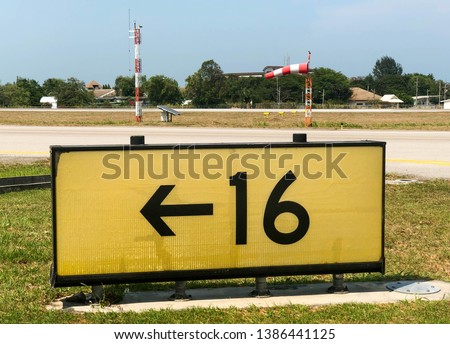 Close up yellow Taxiway sign besides the airport taxiway 
