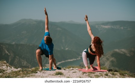 Close Up Of Yoga Couple  With Their Arms Up Standing On The Yoga Mats At The Top Of The Mountain