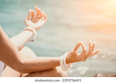 Close up Yoga Hand Gesture of Woman Doing an Outdoor meditation. Blurred sea background. Woman on yoga mat in beach meditation, mental health training or mind wellness by ocean, sea - Powered by Shutterstock