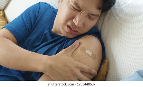 Close Up Young Adult Attractive Hipster Asia Man Receive Covid-19 Anti Virus Vaccine In Campaign Vaccination Safe Life Got Side Effect Pain At Arm. Vaccine Rollout Swelling In Volunteer.