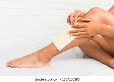 Close Up Of A Young African American Woman Waxing Her Legs