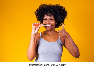 Close Up Of A Young African American Woman Brushing Her Teeth With A Toothbrush