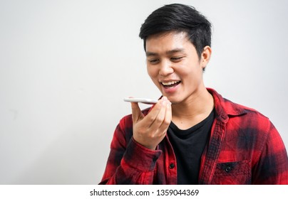 close up young asian man holding smartphone and talking by use voice control function for call with others, lifestyle technology concept - Powered by Shutterstock