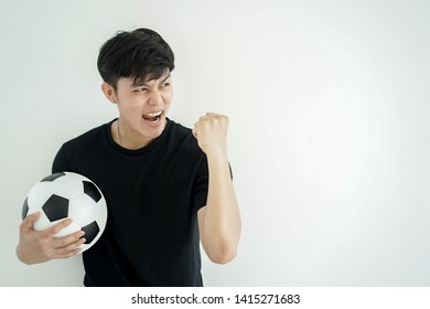 Close Up Young Asian Man Looking Raising Hand And Holding Football With Feeling Excited Or Happy After Football Team Become A Champion Of The Year Isolated On White Background , Millennial And Technol