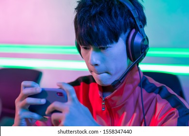 Close Up Of Young Asian Teenage Cyber Sport Gamer Play Mobile Game By Smartphone On ESport Tournament