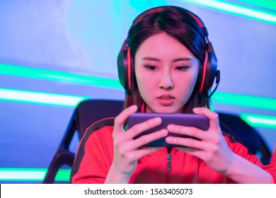 Close Up Of Young Asian Teenage Cyber Sport Gamer Play Mobile Game By Smartphone On ESport Tournament