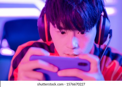 Close Up Of Young Asian Teenage Cyber Sport Gamer Play Mobile Game By Smartphone On ESport Tournament