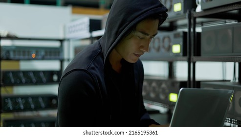 close up of young asian thief hacking into mining farm to steal crypto currency earnings from nft investors