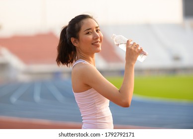 Close up young Asian woman drink water from a plastic bottle after do sport in the morning. - Shutterstock ID 1792792171