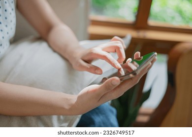 Close up of Young Asian woman student or freelancer 's hand enjoy playing social media, chatting, online shopping watching internet platform, play game by smart phone or mobile phone. Weekend activity - Powered by Shutterstock