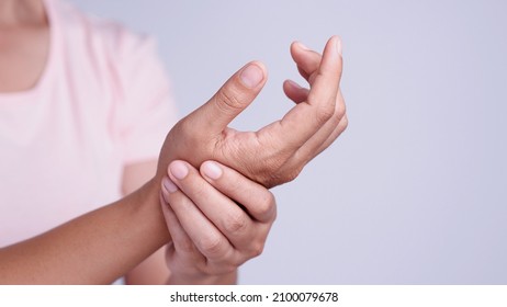 Close Up Young Asian Women Suffering Pain In Hand Around Finger Joint And Using The Thumb To Massage, Exercise, Treatment Her Painful. Concept Of Office Syndrome, Neuropathy, Hand Pain, Healthy Care.