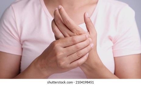 Close Up Young Asian Women Suffering Pain In Hand Around Finger Joint And Using The Thumb To Massage, Exercise, Treatment Her Painful. Concept Of Office Syndrome, Neuropathy, Hand Pain, Healthy Care.