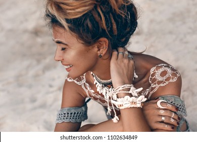 close up of young beautiful boho woman portarait with traditional ornament outdoors at sunset