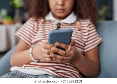 Close up of young Black girl holding smartphone in hands and browsing internet or playing mobile game copy space - Powered by Shutterstock