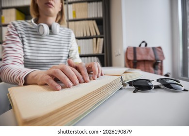 Close up of young blind woman reading Braille book in college library, copy space - Powered by Shutterstock