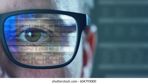 Close up of young businessman with brown eyes wearing the glasses looking on the waveform lines expressed concept of stock market,augmented reality, technology, stock exchange  and finance