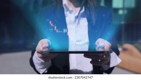 Close up of young businesswoman using digital computer tablet near office building. Bar graph with auto trading computer coding artificial intelligence technology, AI.