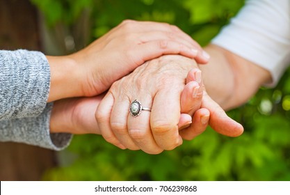 Close Up Young Caregiver Holding Elderly Female's Trembling Hands, Parkinson Disease