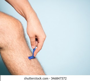 Close Up Of Young Caucasian Man Shaving Hair From Legs