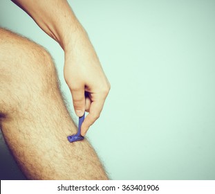 Close Up Of Young Caucasian Man Shaving Hair From Legs