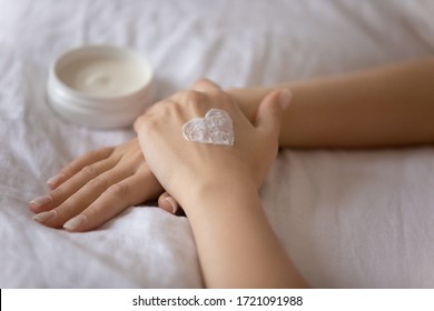 Close up of young Caucasian woman apply nourishing body cream on dry hands for soft healthy skin, female use moisturizing butter or balm beauty product, do daily procedures at home, skincare concept