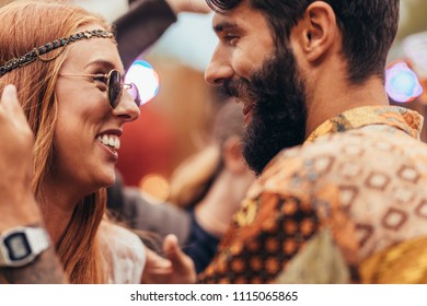 Close up of young couple dancing at music festival. Man and woman in hippie style having fun outdoors. - Powered by Shutterstock