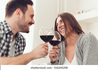 Close Up Of A Young Couple Enjoying Wine At Home.