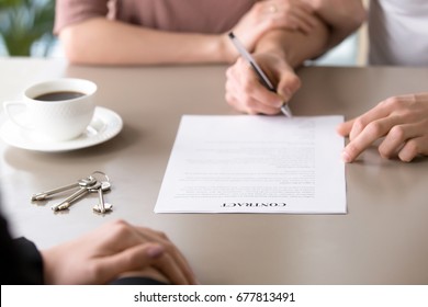 Close up of young couple signing contract, agreed terms and approved application for mortgage with low interest rates, taking home loan, meeting with bank worker or real estate agent