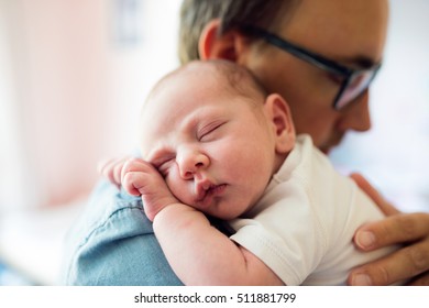 Close up of young father holding his newborn baby son - Powered by Shutterstock