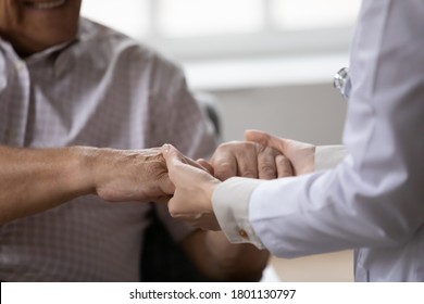 Close Up Young Female Doctor Medical Social Worker Gp Holding Wrinkled Hands Of Elderly Mature Retired Man, Giving Professional Psychological Help, First Aid, Supporting In Stressful Life Situation.