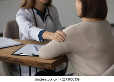 Close Up Young Female Doctor Physician General Practitioner Putting Hand On Older Patient Shoulder, Giving Psychological Support Or Help, Encouraging During Illness Treatment, Good Medical Service.