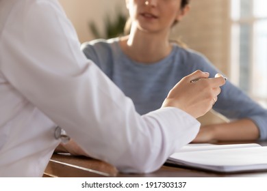 Close Up Young Female General Practitioner Gesturing, Communicating With Patient At Checkup Meeting In Clinic Office. Focused Doctor Explaining Medical Insurance Benefits Or Health Treatment Protocol.