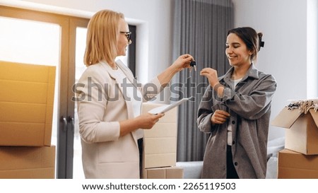 Close up young female real estate agent giving keys to happy buyer, congratulating with purchasing apartment. Millennial woman taking in leasing new house, accommodation tenancy rental service concept
