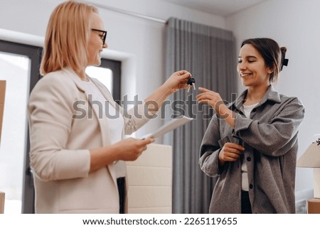Close up young female real estate agent giving keys to happy buyer, congratulating with purchasing apartment. Millennial woman taking in leasing new house, accommodation tenancy rental service concept