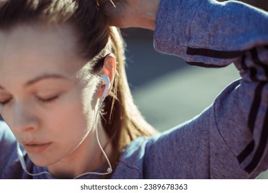 Close Up of a Young Female Runner Adjusting Earphones Before a Jog - Powered by Shutterstock