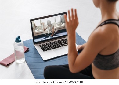 Close Up Of Young Fit Woman Coach In Sportswear Conducting Online Fitness Training Or Virtual Yoga Class On A Video Conference With Laptop. Home Workout Training. Health Practice And Wellness Concept 