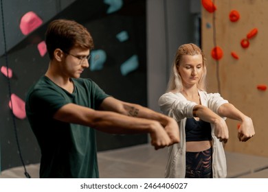 close up young girl at a climbing wall with a trainer doing a warm-up before rock climbing training - Powered by Shutterstock