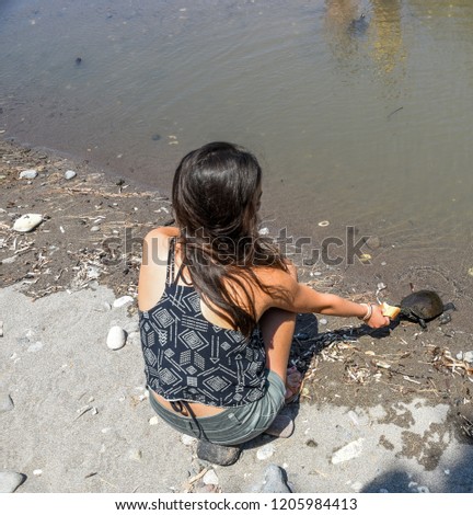 Close up of young girl feeding turtles at the beach