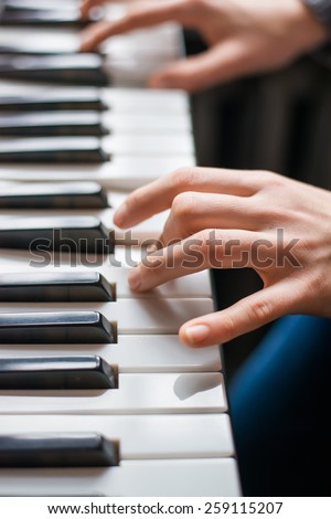 Close up of young girls hands, playing the keys