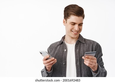 Close Up Of Young Guy Paying With Mobile Phone App And Credit Card, Shopping Online, Insert Bank Number To Make Purchase, Order In Internet, White Background