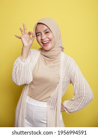 Close Up Young Hijab Women Happy And Show The OK Sign Isolated On A Yellow Background