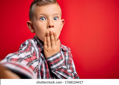 Close Up Of Young Little Caucasian Kid With Blue Eyes Taking A Selfie Photo Over Red Background Cover Mouth With Hand Shocked With Shame For Mistake, Expression Of Fear, Scared In Silence.